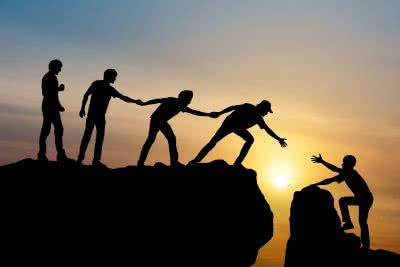 People helping each other across difficult ground